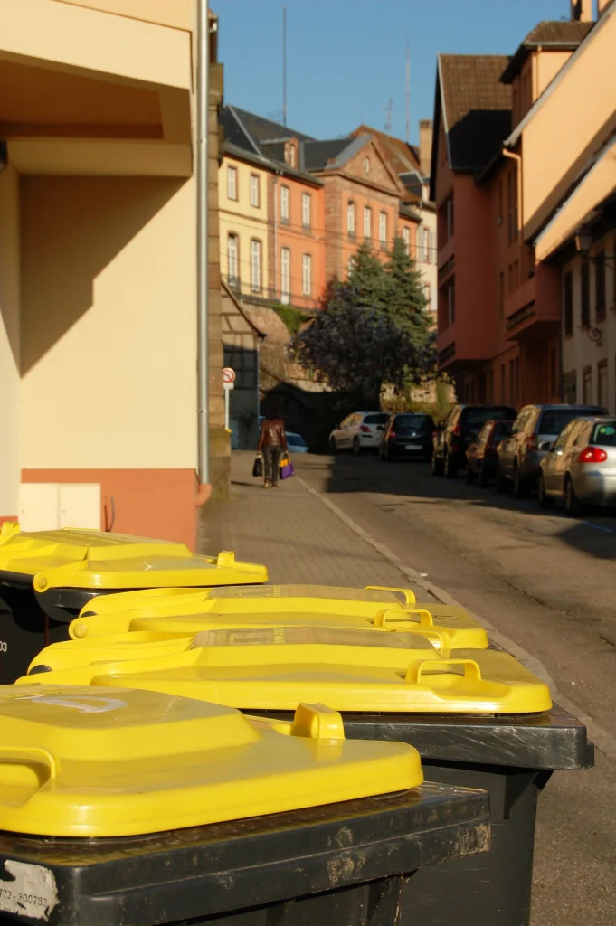 Poubelles jaunes individuelles dans une rue.